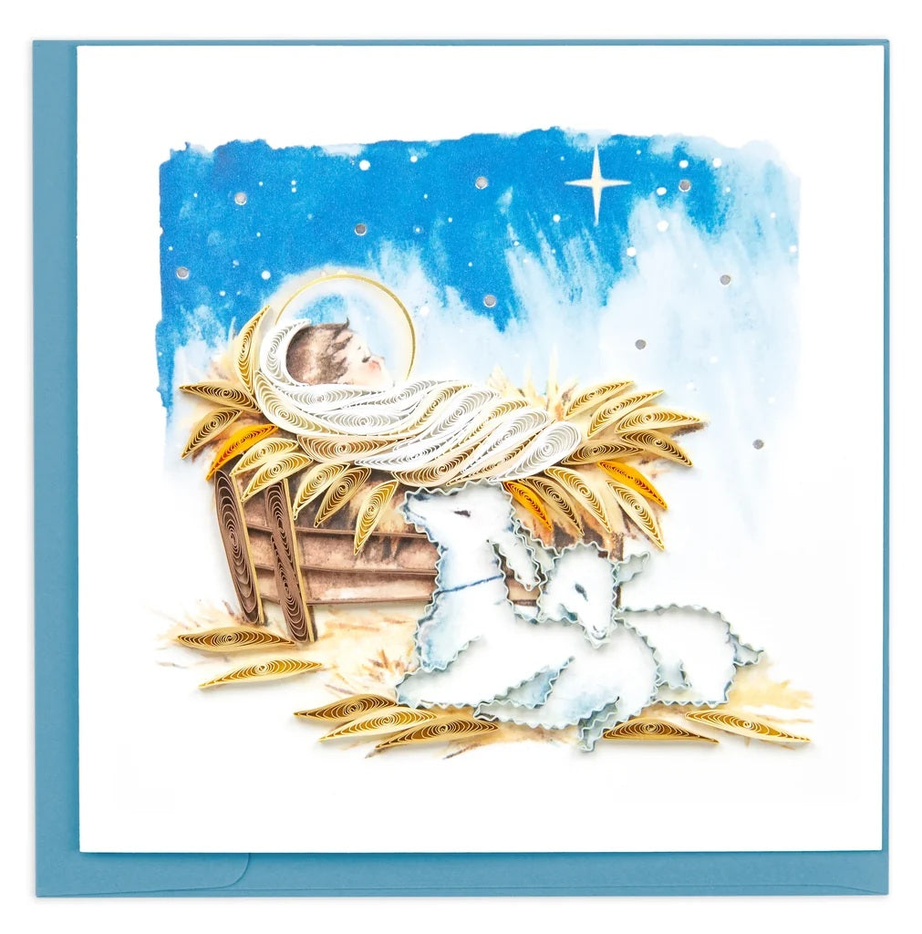 Quilled Baby Jesus in Manger Greeting Card — dimensional paper quilled nativity scene with Baby Jesus in golden halo, two lambs, and Star of Bethlehem against a blue night sky, blue envelope